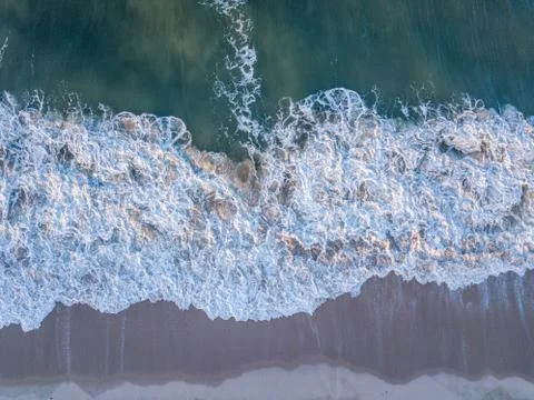 Drone picture of waves hitting the beach. Stock Photos
