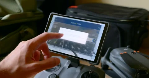 Drone pilot checking a weather map on a remote controller Stock Footage 331029478