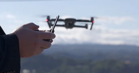 Drone pilot hands control aircraft flying in background during day 4K Stockbeeldmateriaal 83676752