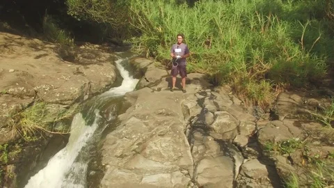Drone Pilot Operatoring drone standing over Small Waterfall Video stock 71842538