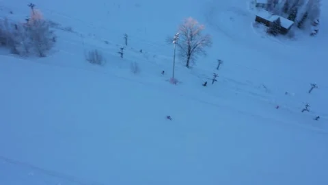 Drone pitching down to capture snowy ski run Stock Footage 323175304