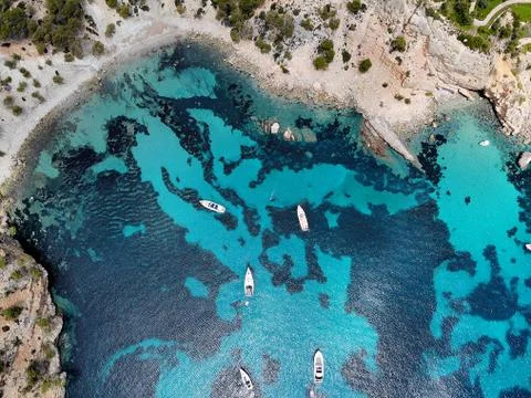 Drone point of view directly from above moored yachts on the bright blue bay Stock Photos