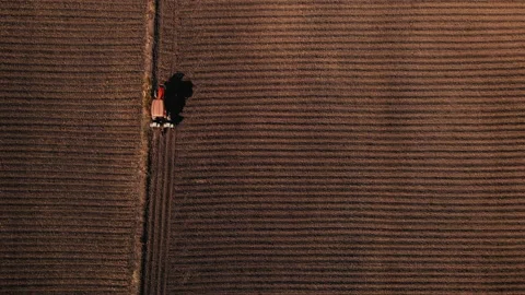 Drone point of view farmer driving tractor corn planting machine Stock Footage 167787157