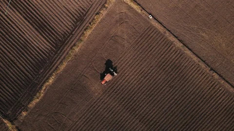 Drone point of view farmer driving tractor crop planting machine in field Stock Footage 168365322