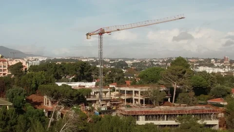 Drone point of view moving up around crane tower in construction site Stock Footage 220862743