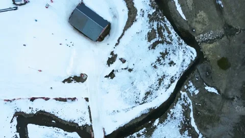 Drone POV hovering over a meandering river at the bottom of ski resort Stock Footage 221835971