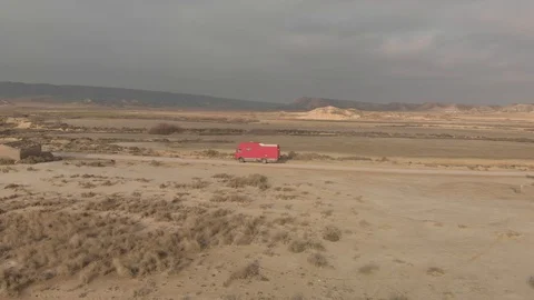 Drone Profile Track Red Bus Driving at Desert Bardenas Reales Vídeos de archivo 103317771