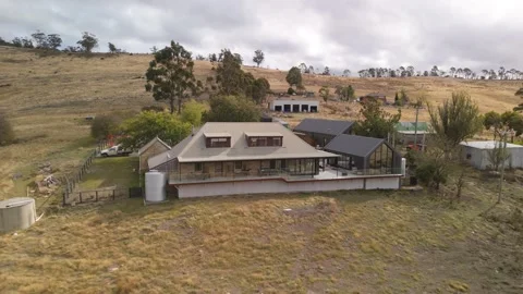 Drone pull-away from a luxury stone villa in Tasmanian highlands under cloud. 库存影片 332542268