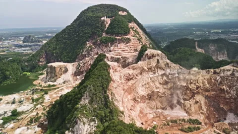 Drone pull-away over limestone quarry, mogotes scraped by machinery, Malaysia Stock Footage 316691808