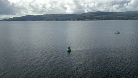Drone pull-away shot of navigation buoy (green) in Scottish loch, 4K. Video stock 248792753
