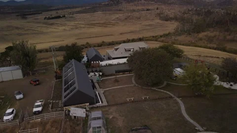 Drone pull-back and tilt-up from a villa to a mountain peak under clouds. Vídeo Stock 332542318
