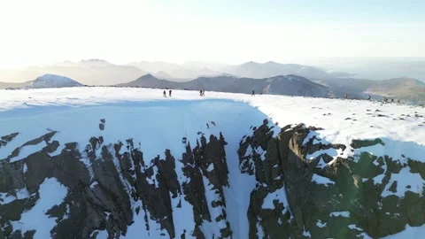 Drone pull back from Ben Nevis summit revealing North Face in winter sun Stock Footage 330576768