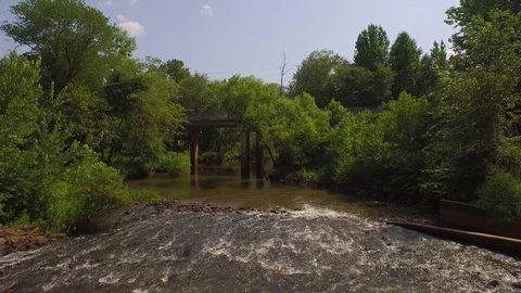 Drone Pull back boom down over muddy river bridge Stock Footage 85377250