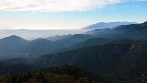 Drone pull back flight revealing layered mountain ridges and valley landscape Vídeos de archivo 329284607