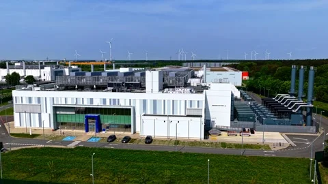 Drone Pull Back from Large Modern Data Center with Wind Turbines Germany Stock Footage 336102483