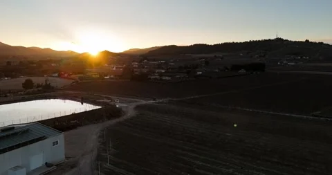 Drone Pull Back Over Sunset Fields and Reflective Pond Stock Footage 335946517
