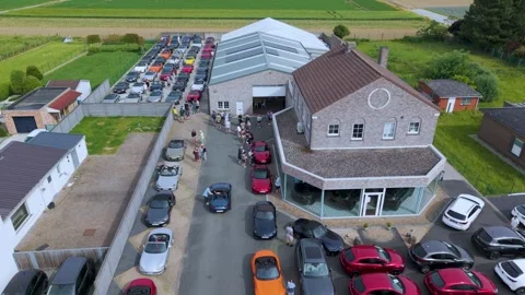 Drone Pull Back Revealing Automotive Dealership and Parked Roadsters Stock Footage 340535830