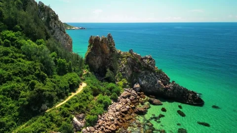 Drone pull back sequence over vertical sea rocks and clear water 4K Stock Footage 340069001