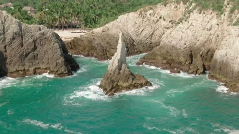 Drone pull back shot at Dedo de Dios iconic landmark, located at Maruata Beach Stock Footage 336465179