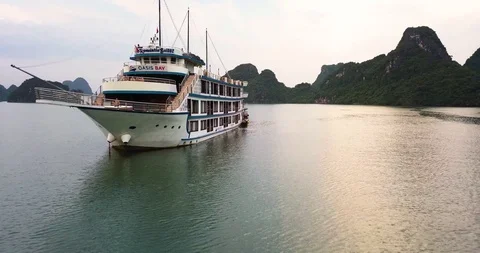 Drone pull out of large cruise ship in Halong Bay Vietnam during sunset Stock Footage 97434548