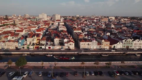 Drone pull out over Aveiro canal waterfront with colorful houses and barge, Ria Vídeo Stock 328978106