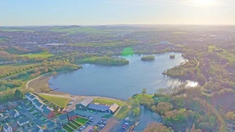 Drone pull out over Manvers Lake in Rotherham showing lakefront, houses and Vídeos de archivo 310665558