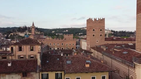 Drone pull-out over Verona rooftops revealing historic towers and medieval Vídeos de archivo 312312633