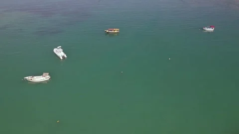 Drone pull up shot of docking boats, calm ocean, Stock Footage 320669875