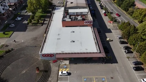 Drone pull‑away of COOP grocery store and parking in Salsomaggiore Terme, Italy Stock Footage 323874390