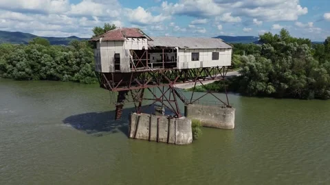 Drone pullback from abandoned coal loader on river with nature background Stock Footage 314346266