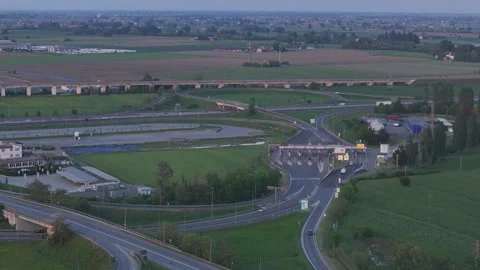 Drone pullback above Fiorenzuola d'Arda toll plaza and motorway interchange Stock Footage 336626116