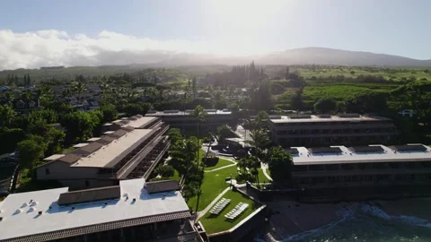 Drone pullback above hotel lawn and beach in shade above from hotels Stock Footage 263752279