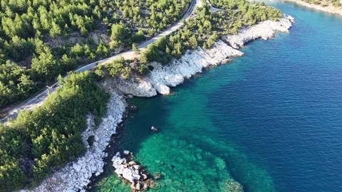 Drone Pullback Along Forested Rocky Shore and Blue Sea Stock Footage 340509090