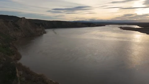 Drone pullback and descent over Tagus river in backlight at sunset Video stock 334661313