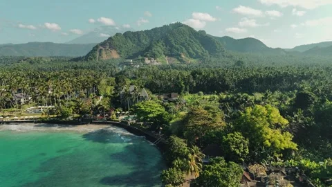 Drone pullback of Candi Dasa Bali coastline with tropical sea and mountains Stock Footage 317171071