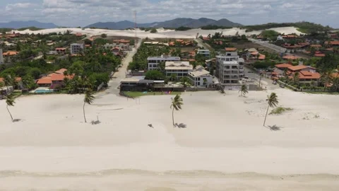 Drone pullback from Cumbuco beachfront resort area to dunes and mountains Ceará Stock Footage 333989366