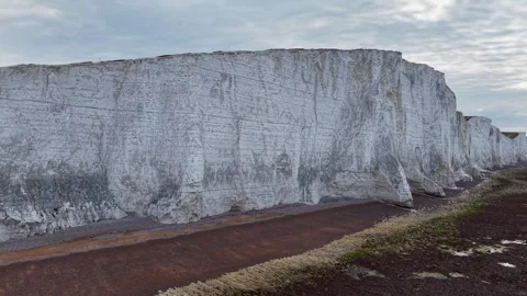 Drone pullback from dramatic white chalk cliffs to vast ocean horizon Stock Footage 309764334