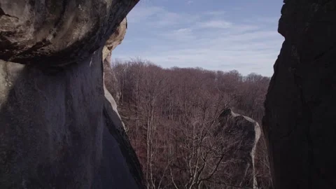Drone Pullback Flying Between Massive Rock Cliffs and Forest Stock Footage 327596728