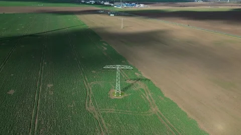 Drone Pullback from High-Voltage Power Line Tower Across Farmland – Germany 4K Stock Footage 341850626