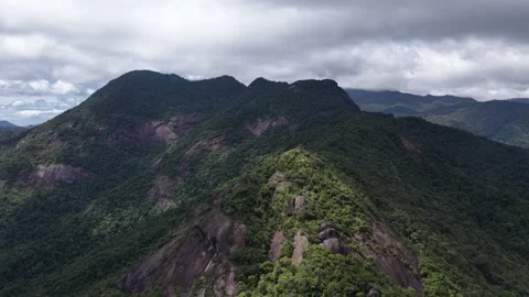 Drone Pullback from a Mountain as Cloud Shadows Reveal Sunlight Stock Footage 343806784