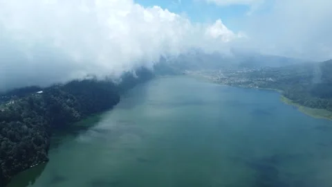Drone pullback over Bali lake into clouds cinematic aerial Stockbeeldmateriaal 312305360
