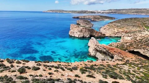 Drone pullback over Blue Lagoon limestone coast and shallow shelf Comino Video stock 333990881