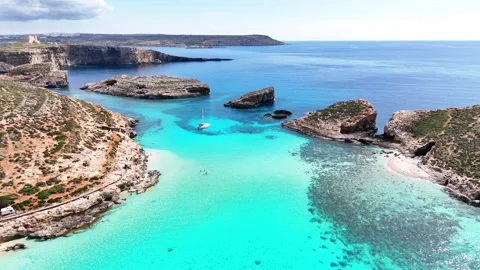 Drone pullback over Blue Lagoon channel and Cominotto islet Comino Malta Video stock 333991794