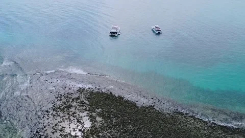 Drone pullback over coral reef edge and anchored boats Abrolhos Archipelago Stock Footage 333976418