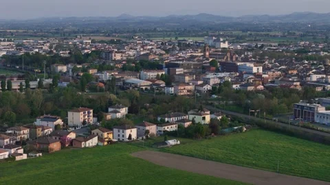 Drone pullback over Fiorenzuola d’Arda with freight train and Apennines Italy Stock Footage 334717383