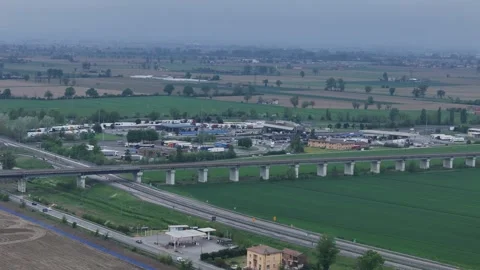 Drone pullback over motorway service area and viaduct in Po Valley near Piacenza Stock Footage 334719578