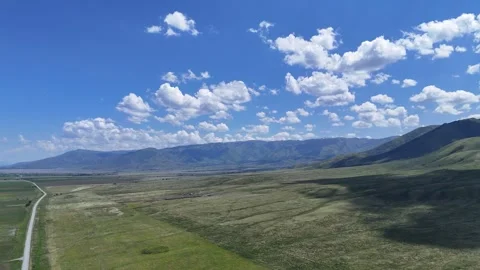 Drone Pullback Over Mountains, Green Meadows and Road Near Bukhtarma, East K Stock Footage 317507154