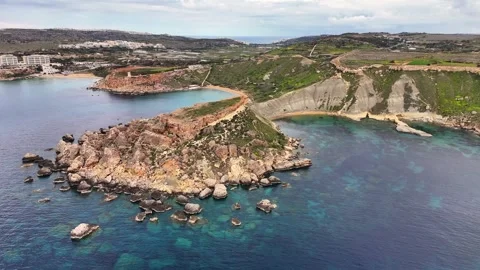 Drone pullback over Qarraba Bay clay cliffs and limestone promontory in Malta Video stock 333991507