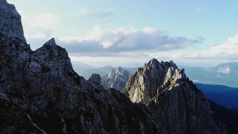 Drone Pullback Past Hiker On Mangart Saddle Cliff At Sunset With Alpine Peaks Stock Footage 334735135