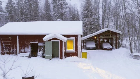 Drone pullback reveal of illuminated room in traditional Swedish house in winter Stock Footage 331756338